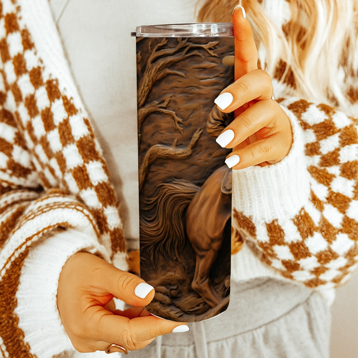 Woman holding 20 oz straight tumbler with 3D tooled leather cowboy design. 