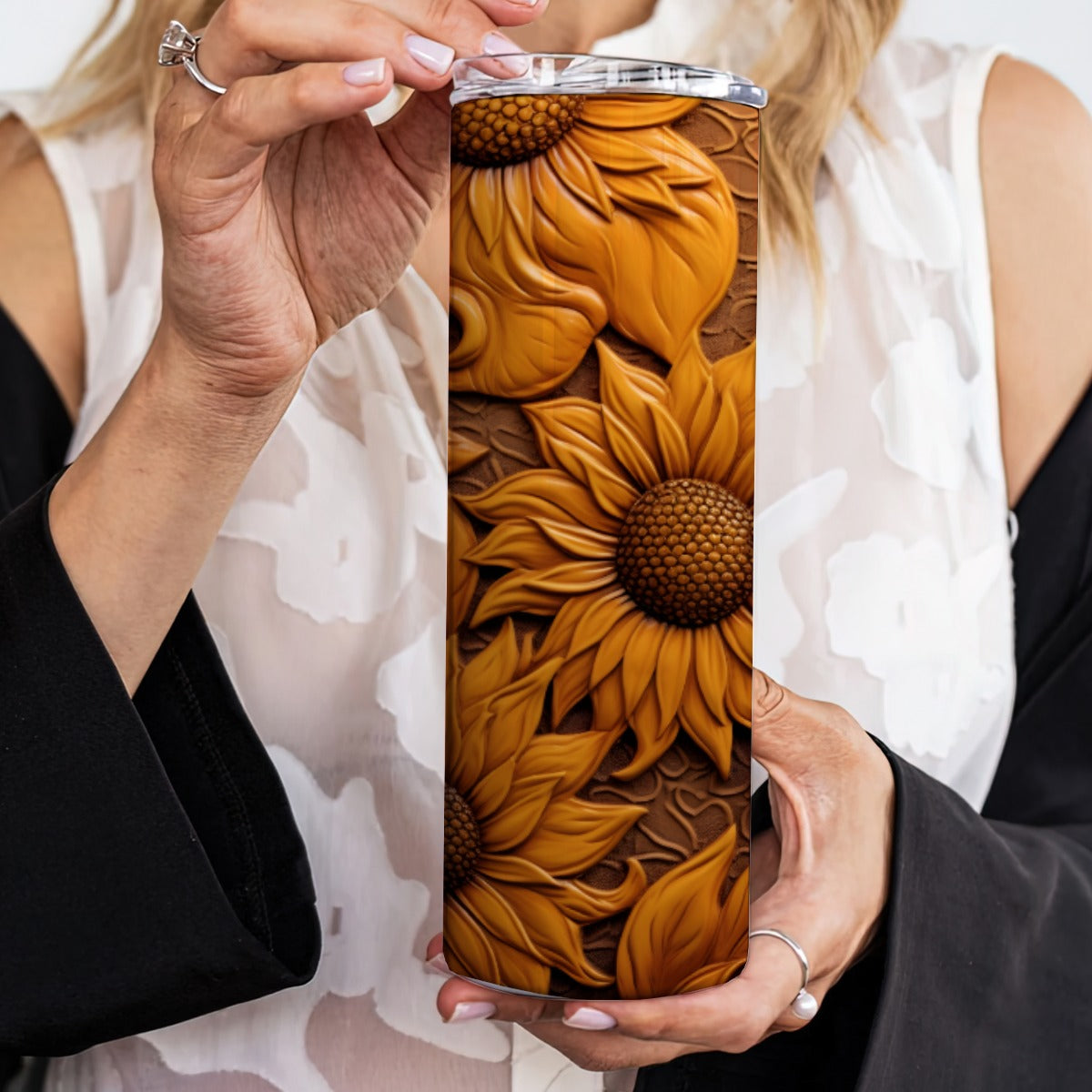 Person holding a 20 oz straight tumbler with 3D tooled leather dark-sunflower design.