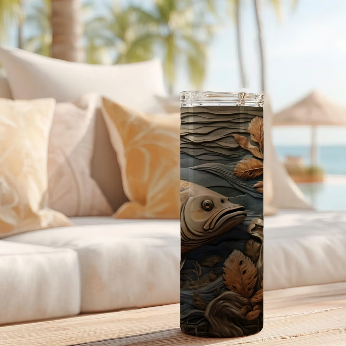 20 oz straight tumbler with 3D tooled leather fish design on a table outdoors.