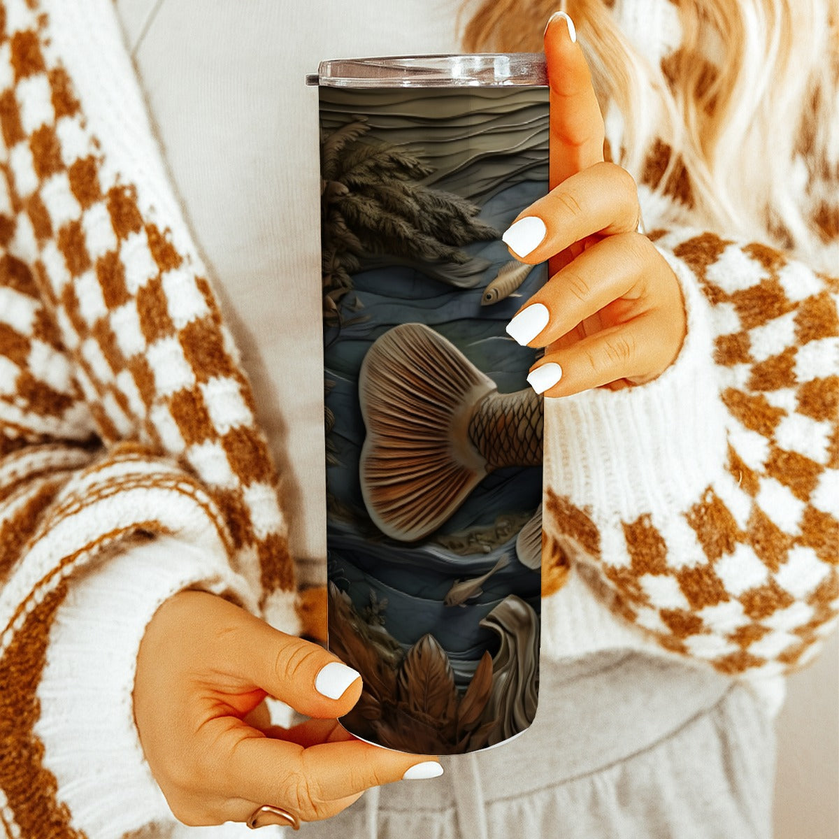 Woman holding 20 oz straight tumbler with 3D tooled leather fish design. 
