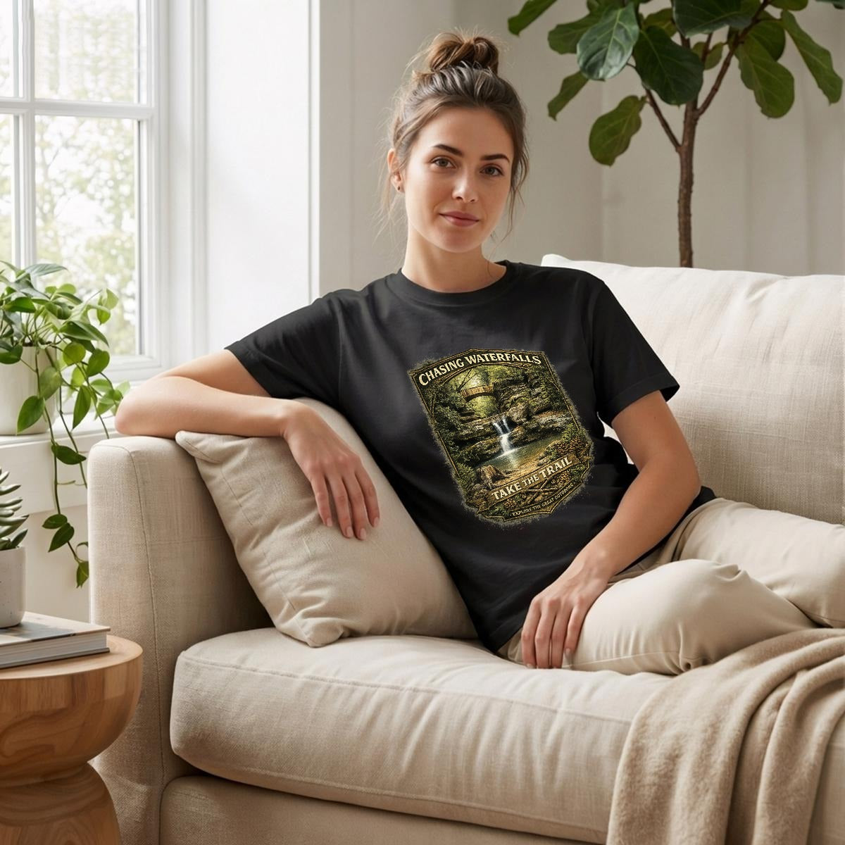 Woman sitting on a couch wearing a black t-shirt - Chasing Waterfalls Upper Old Man's Cave Shirt.