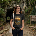 Woman wearing a black t-shirt with graphic design - Country Roads-Take Me Home Shirt, in a nature park.