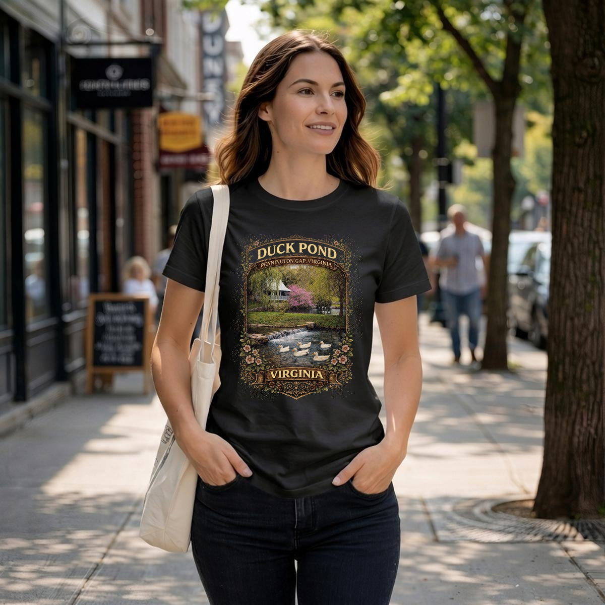 Woman wearing a black t-shirt with a rustic watermill, graphic with text duck pond Pennington Gap, VA.