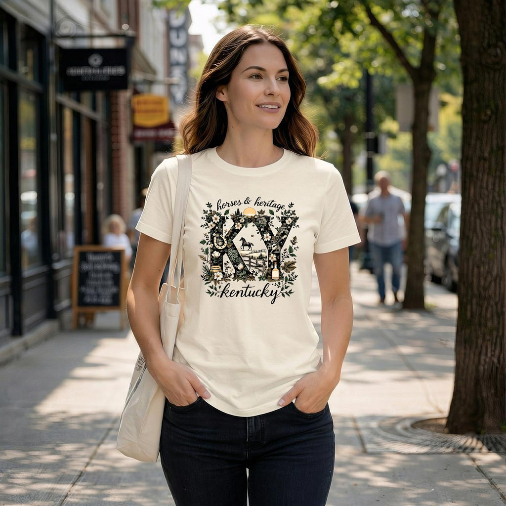 Woman wearing a natural t-shirt with a colorful graphic and text, standing on a sidewalk.