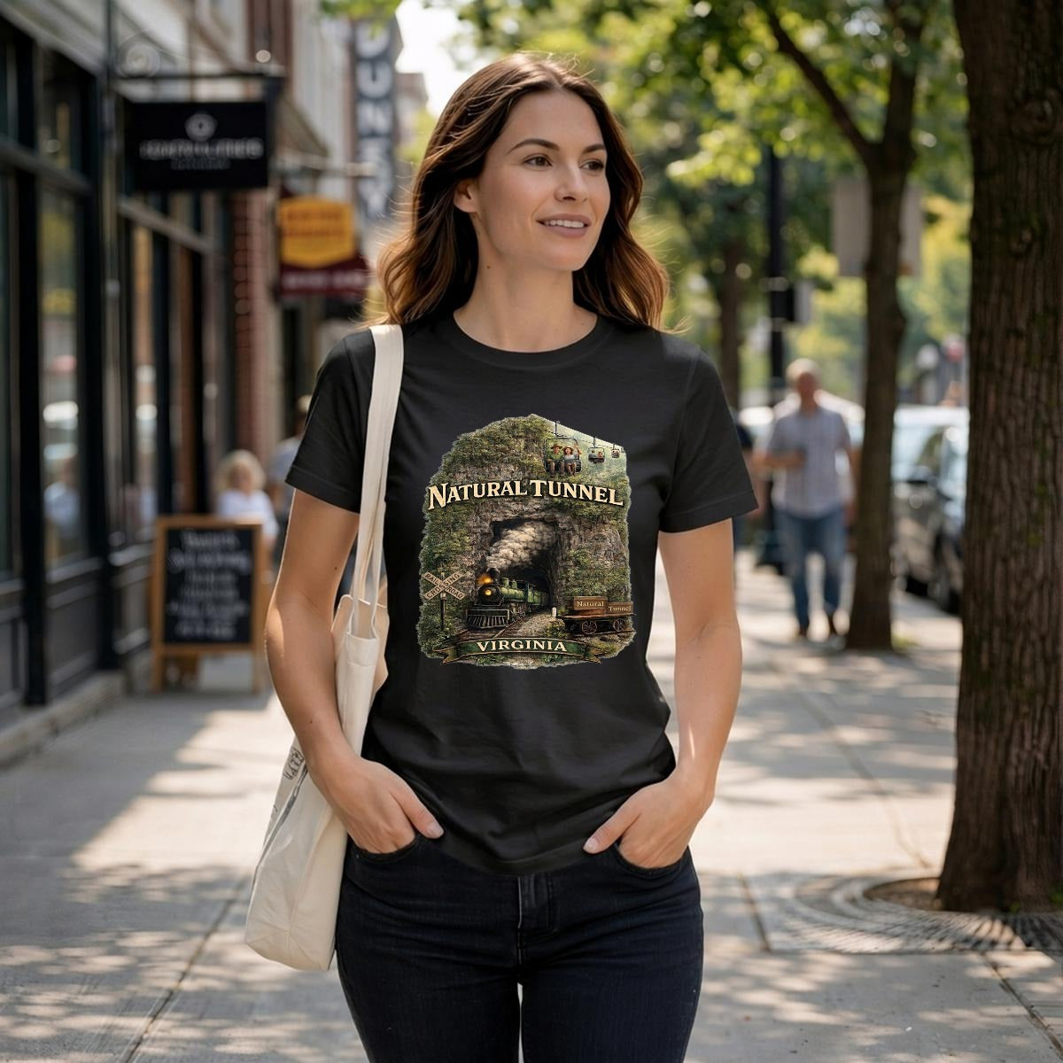 A woman walks down a street wearing a black graphic t-shirt featuring a steam train coming out of a tunnel.