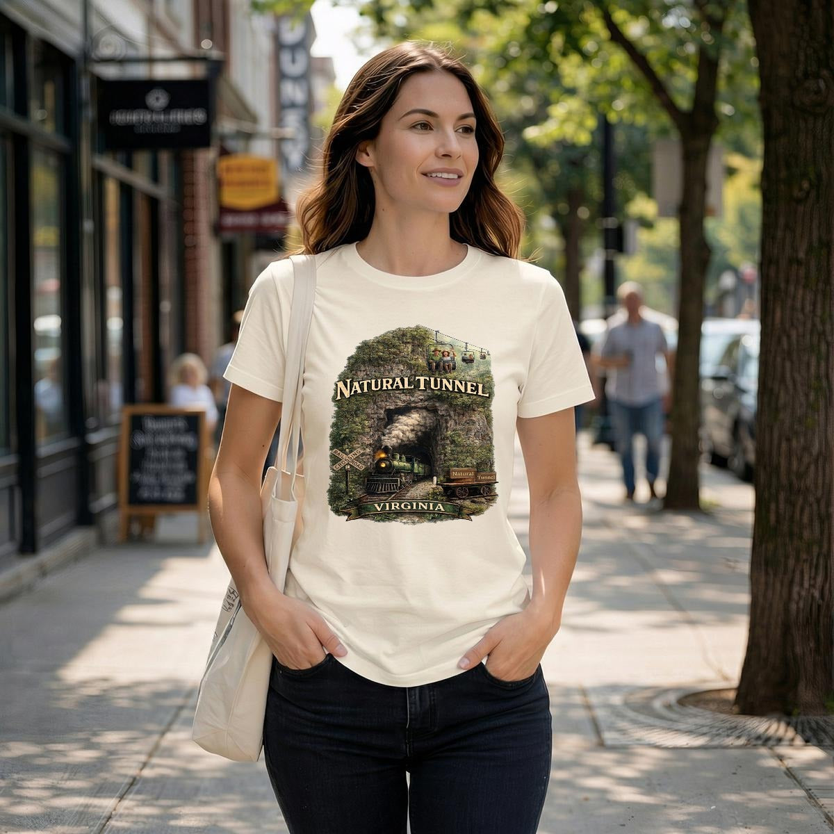 A woman walks down a street wearing a graphic t-shirt featuring a steam train coming out of a cave.
