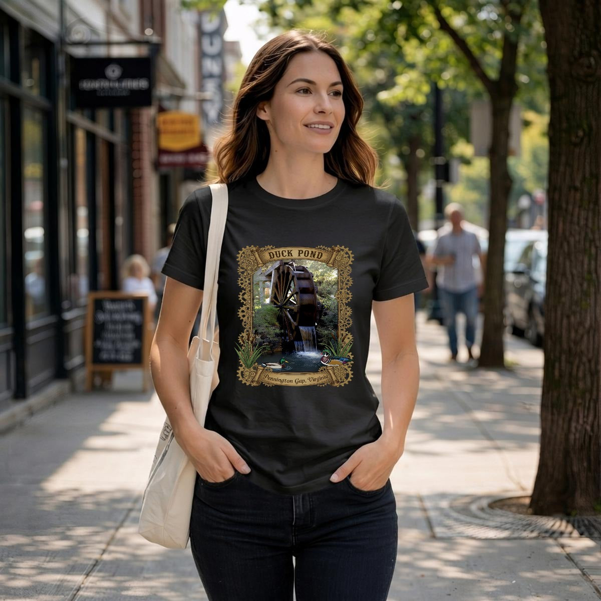 Woman wearing a black tee with a rustic watermill, graphic with text duck pond Pennington, Gap VA.