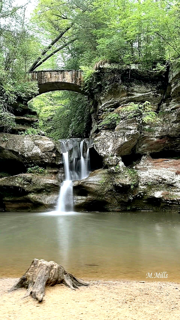 Upper Old Mans Cave waterfall with a stone bridge above it.