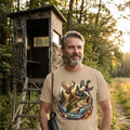 Man wearing a t-shirt with nature-themed design in front of a wooden blind in a forest.