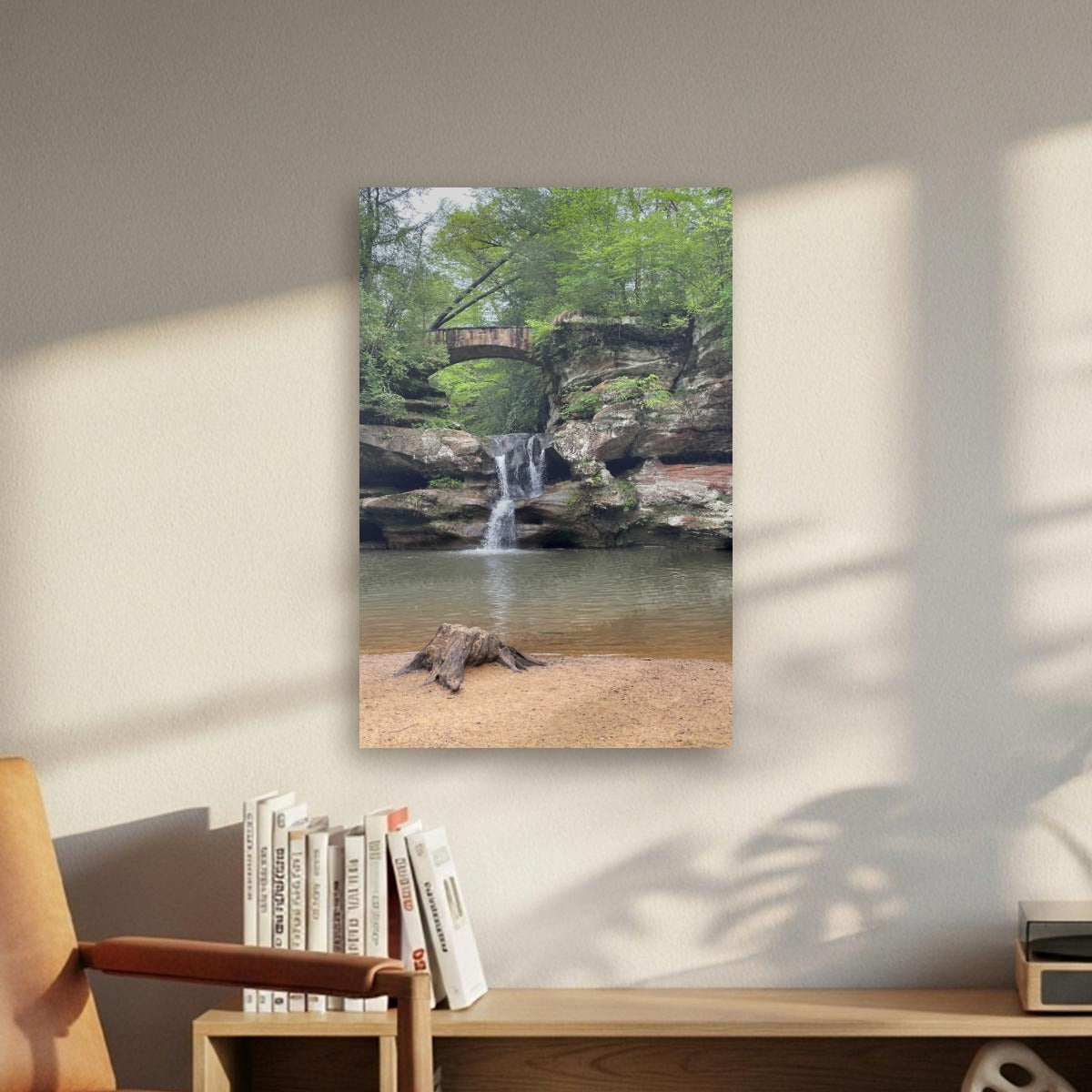 An old wooden stump in sand with waterfall cascade under a Stonebridge vertical canvas.